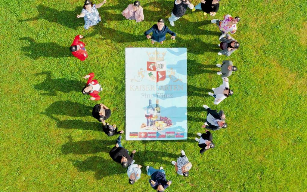 Drohnenaufnahme von Personen die sich in einer Herzform gestellt haben auf einer Wiese