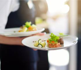 Schweinemedallions im Speck mit Bohnen und Weinglas angerichtet