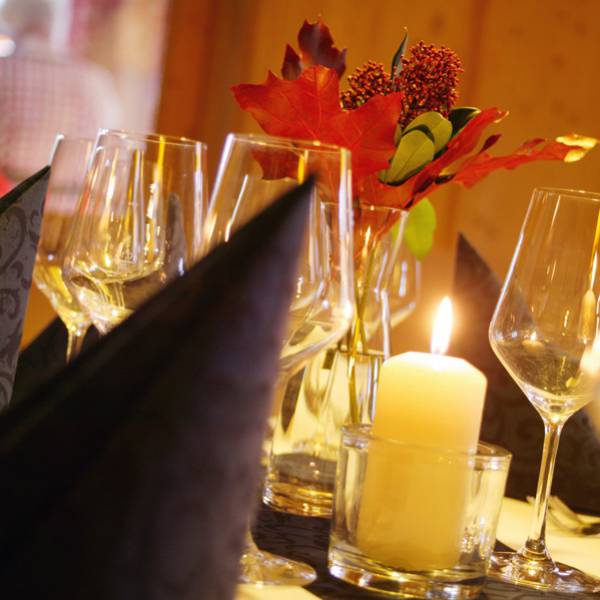 Gedeckter Tisch mit schwarzen Servietten, Weingläser und einer Kerze