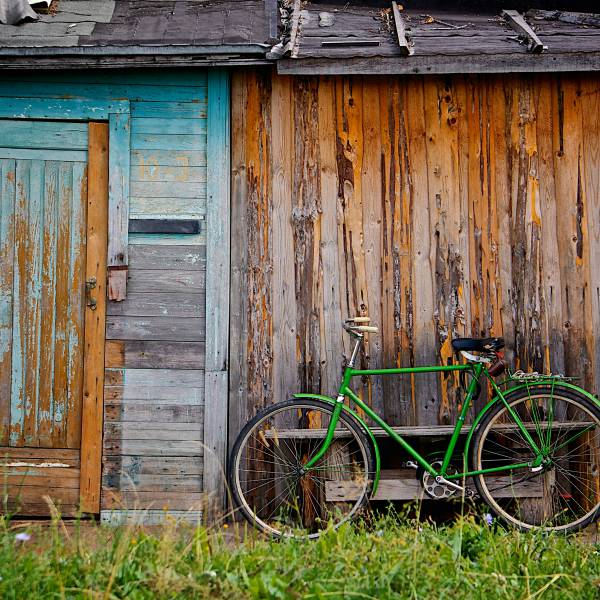 Grünes Fahrrad vor Holzschuppen